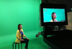 Female-talent-sitting-in-green-screen-studio
