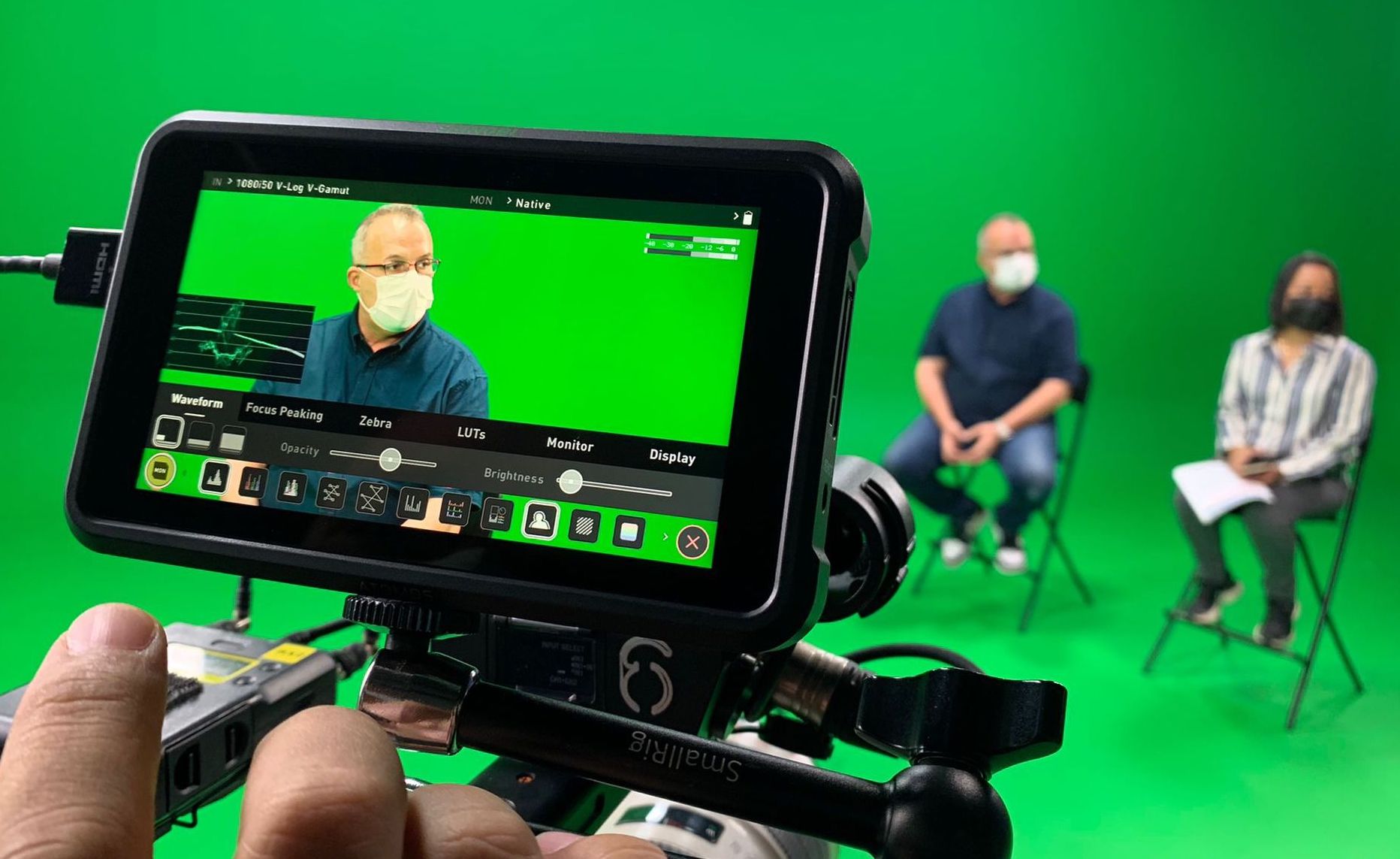 Monitor view of two subjects in green screen studio