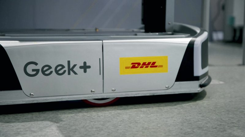 A robo shuttle with GeekPlus and DHL logos